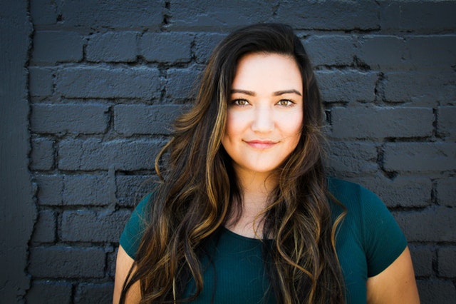 close-up-photography-of-a-woman-near-wall-1065084