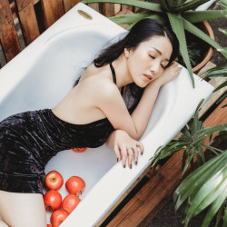 woman-wearing-black-backless-dress-laying-on-white-bathtub-3298452